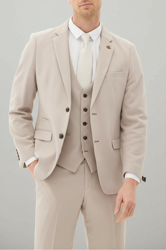 Man wearing a beige suit with a white shirt on a gray background