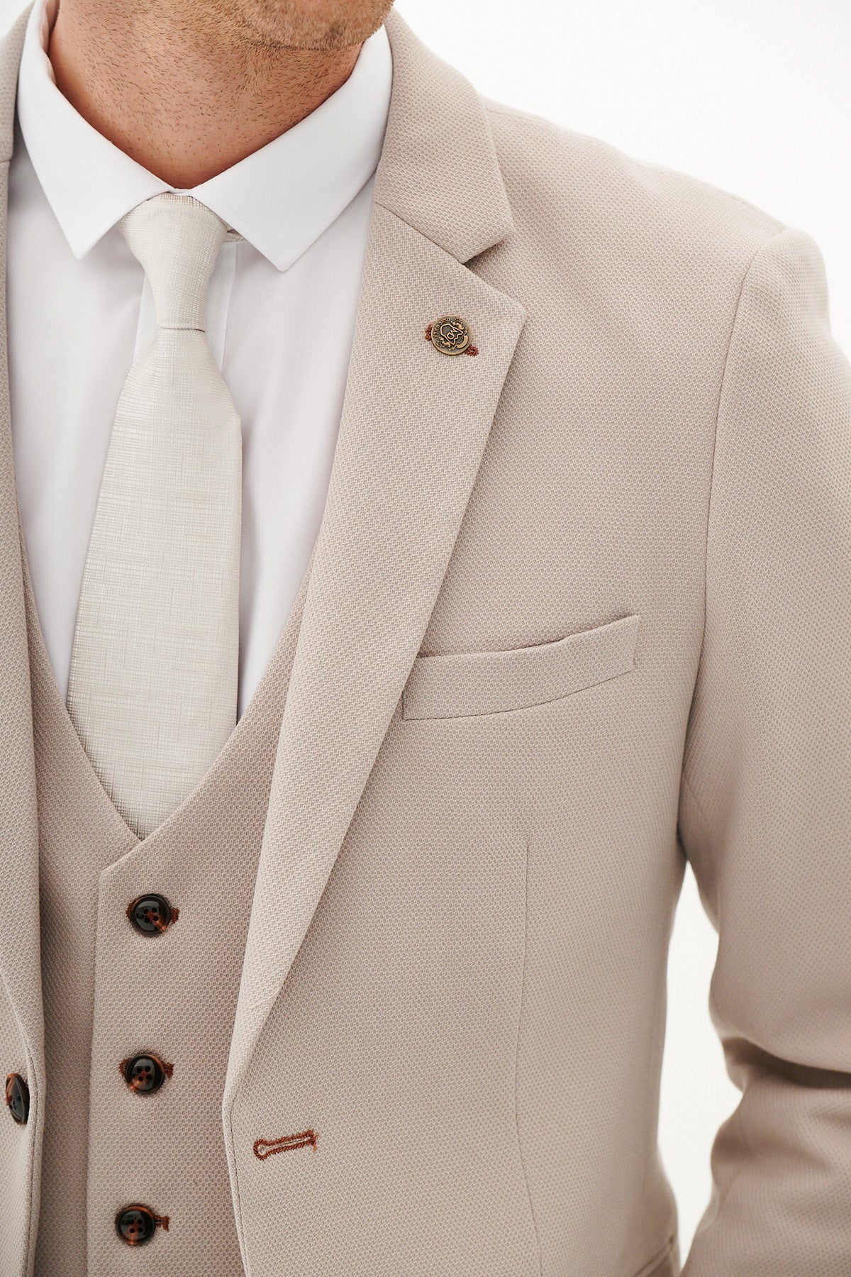 Beige suit with white shirt and tie on a plain background