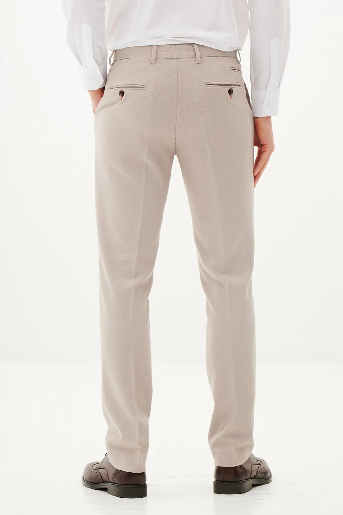 Beige pants worn by a person on a white background